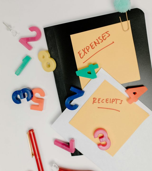 Flat lay of colorful office supplies and sticky notes labeled 'Expenses' and 'Receipts'.